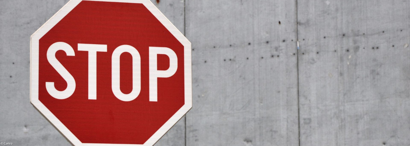 Stoppschild vor grauer Wand